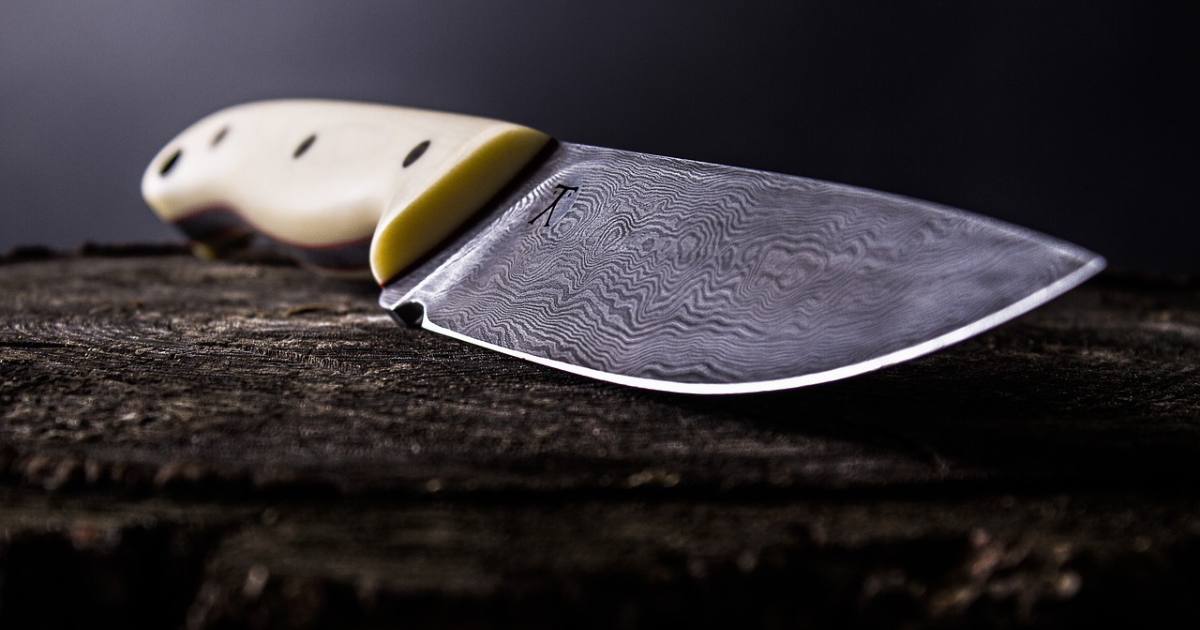un artisan forgeron montrant comment forger un couteau avec une chaine de tronçonneuse pour faire un couteau damas
